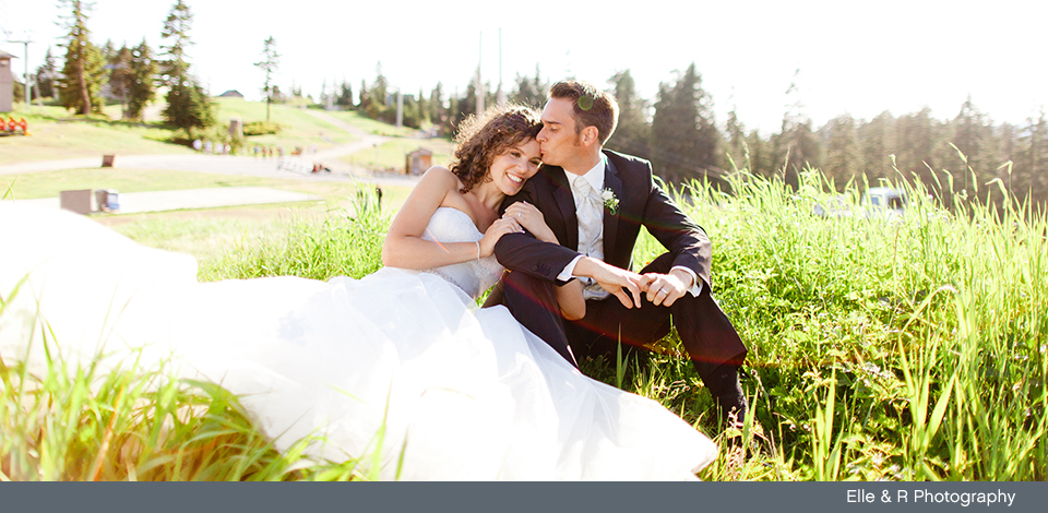 Couple sitting in the grass at Grouse Mountain on their wedding day